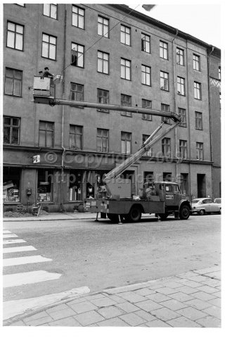 Gatukontoret byter glödlampor i gatubelysningen med en sky lift, Stockholm. (1970)