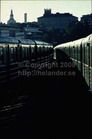 Två tunnelbanetåg vid Gamla stans tunnelbanestation, vy mot Södermalm, Stockholm. (1972)